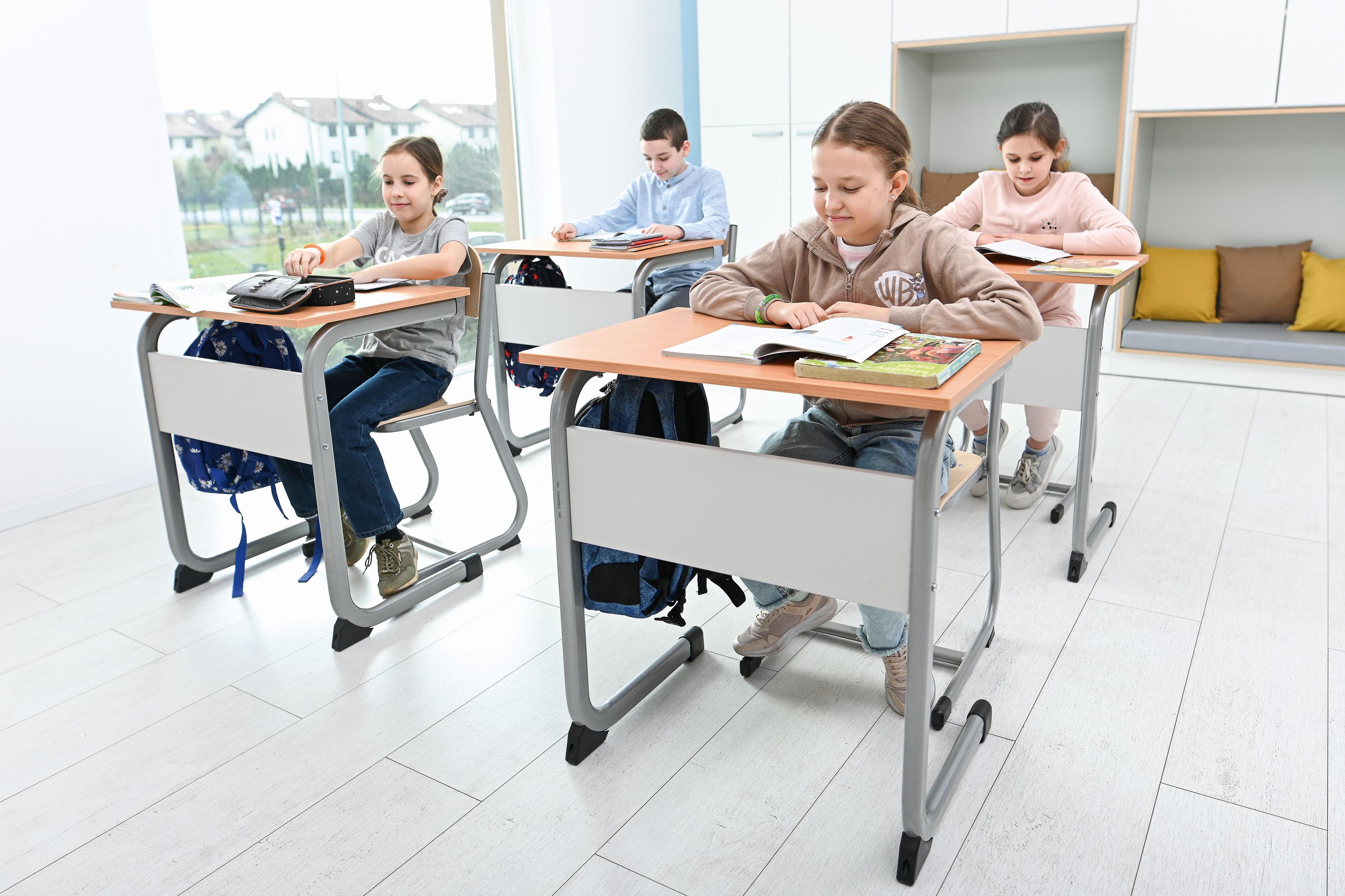 Kinder nutzen bequeme Schülerstühle im Klassenzimmer.