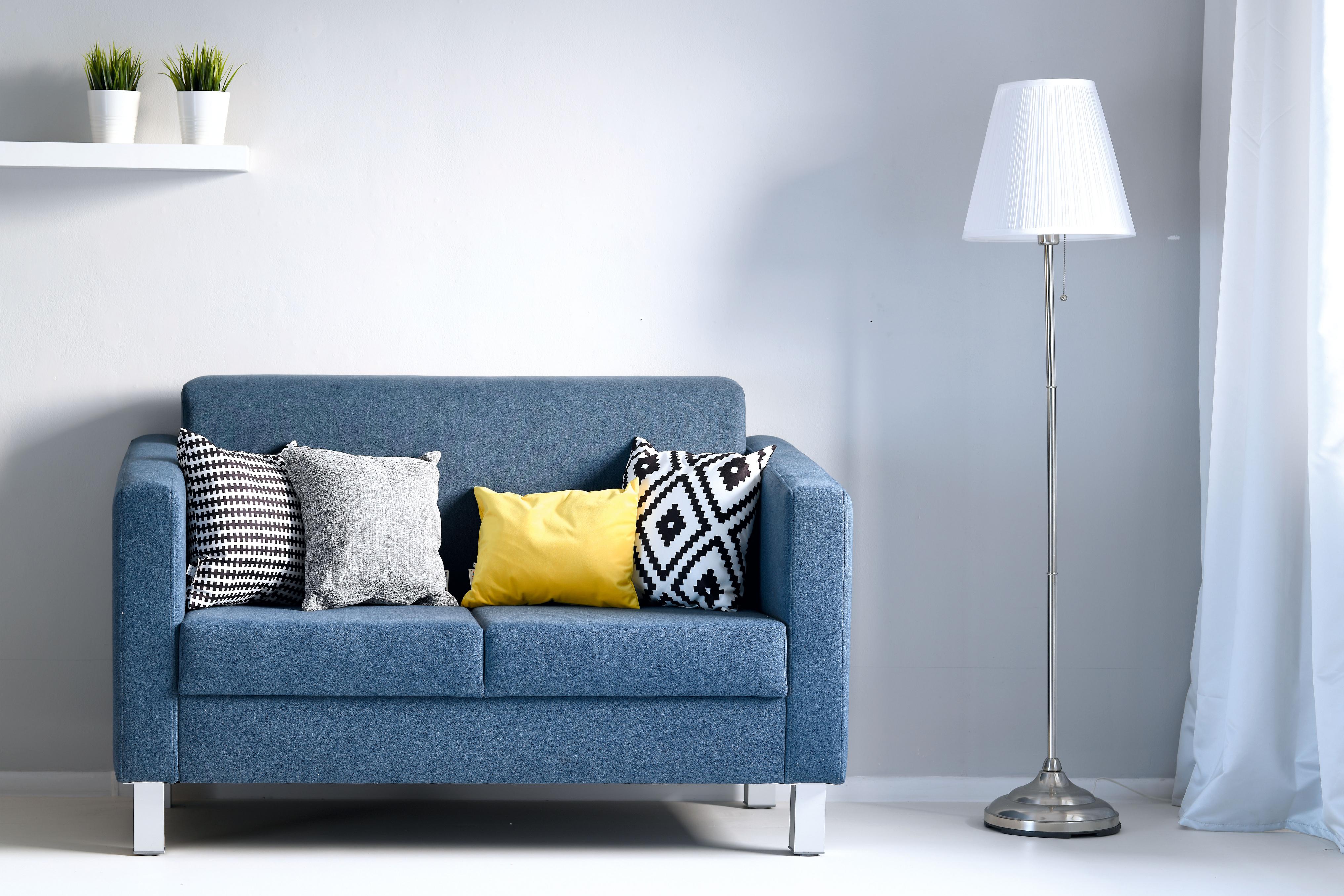 Blaues Sofa mit Kissen im modernen Wohnzimmerdesign.