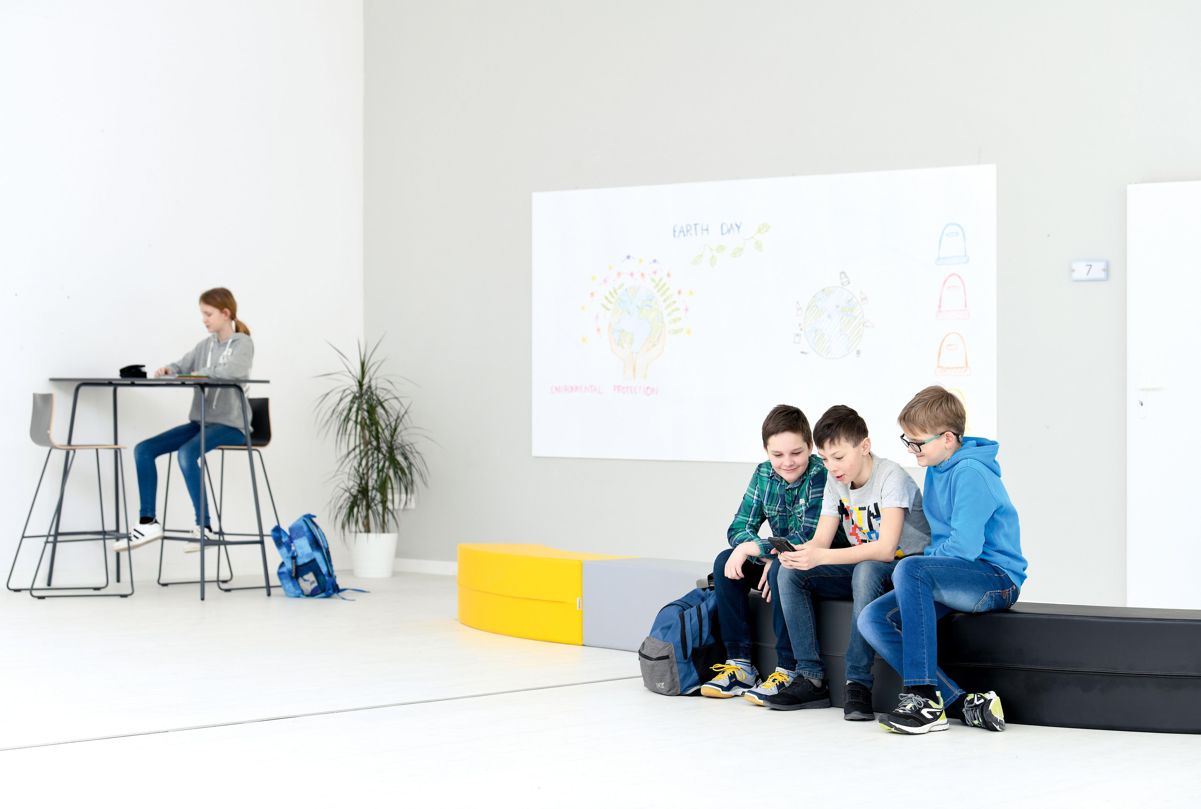 Kind im Klassenzimmer auf Barhocker Cool am Tisch.