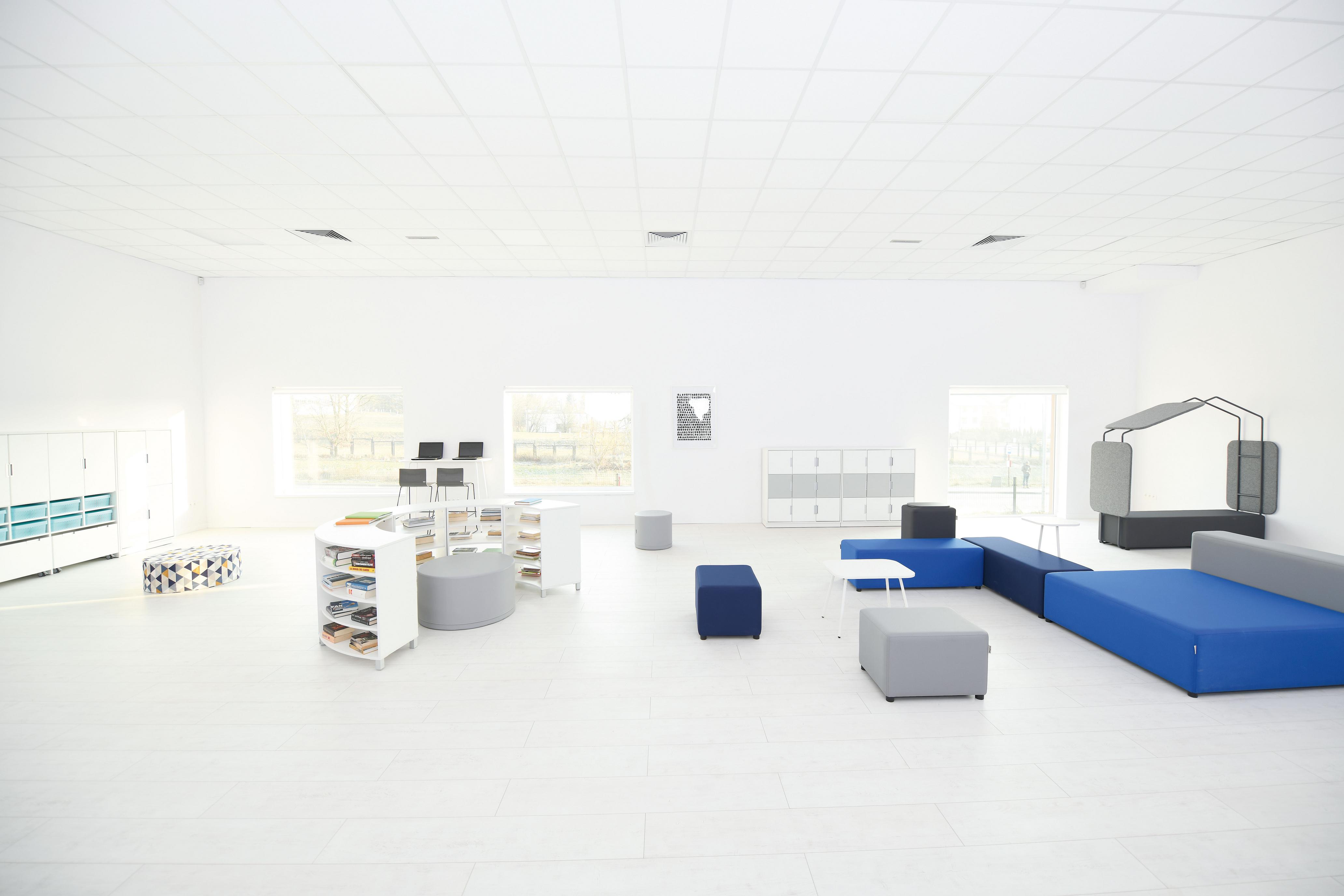 Loungemöbel in Schulraum mit blauen Sitzlandschaften.