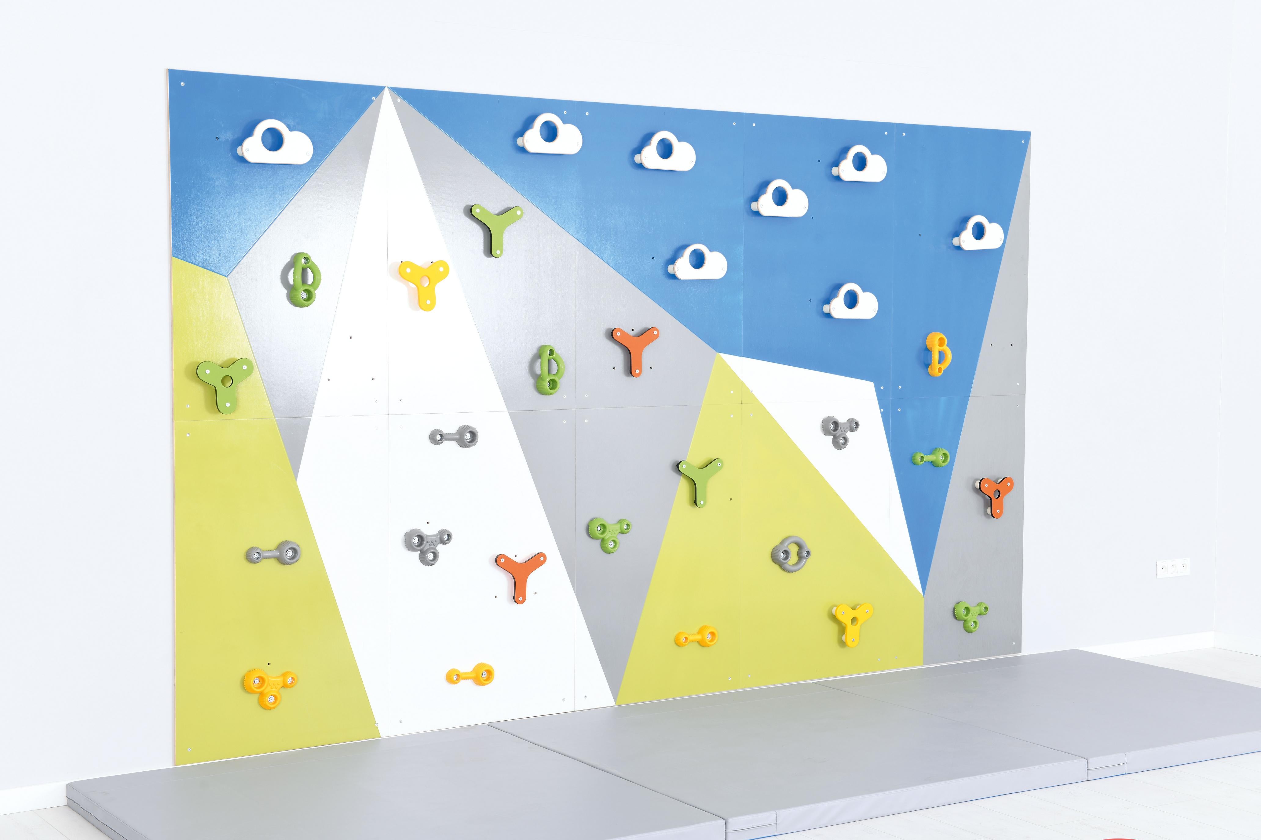 Bunte Kletterwand mit Wolken in Kita-Sporthalle.
