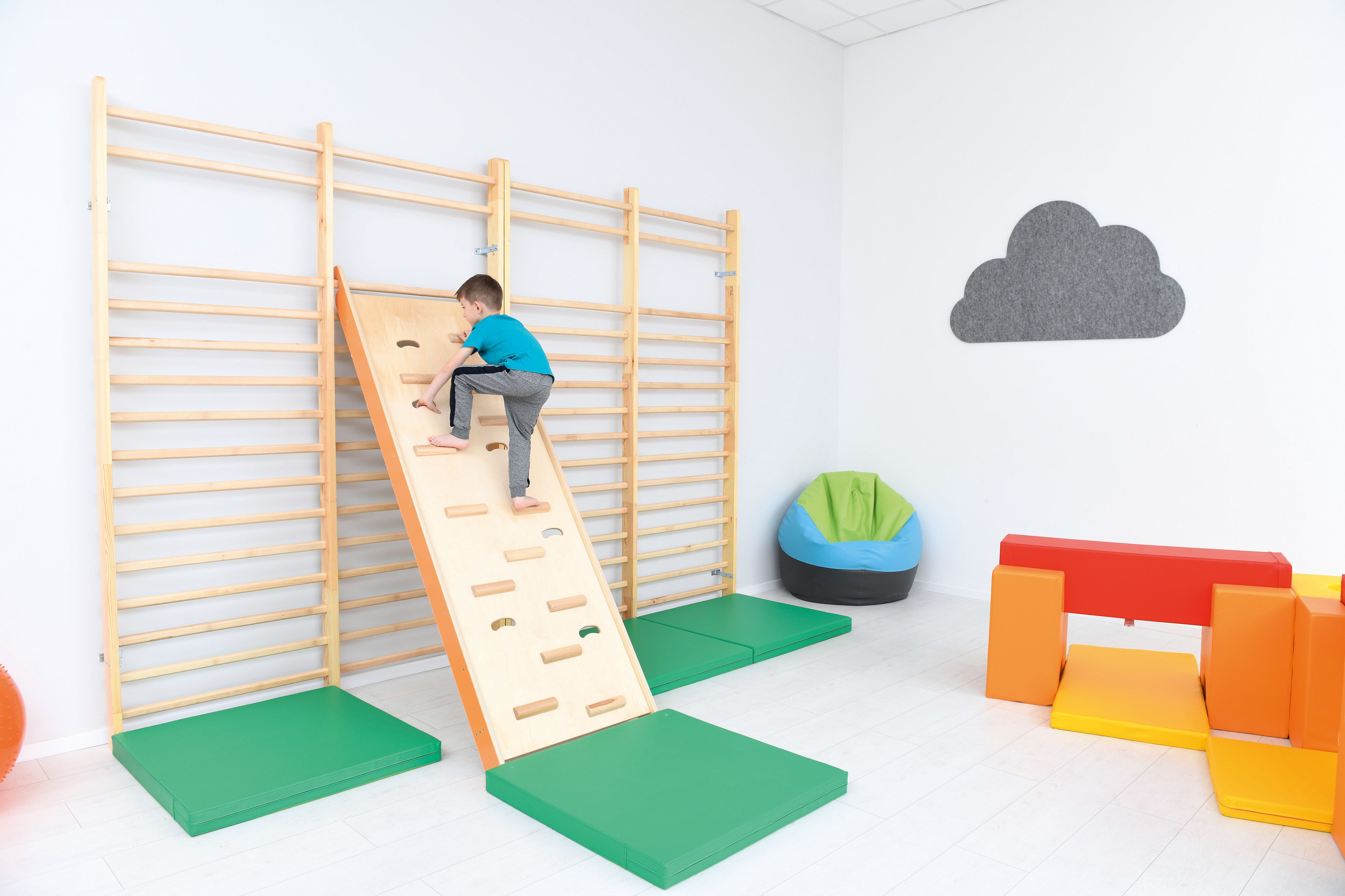 Fallschutzmatte für Kindergarten. Kind an Sprossenwand.