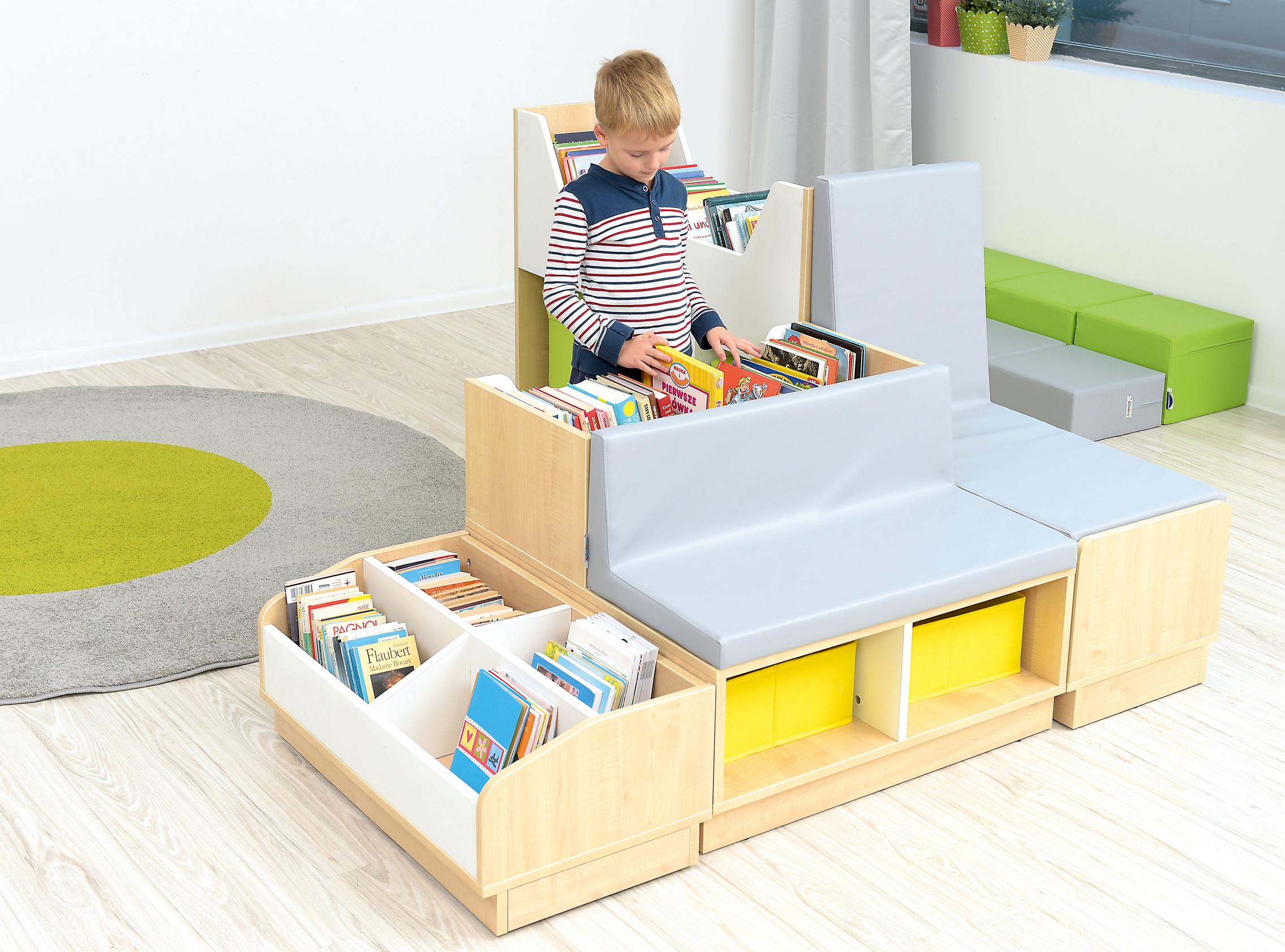 Kind liest an Bücherbank in heller Leseecke. - Produkt wird im Kindergarten oder Schule genutzt.