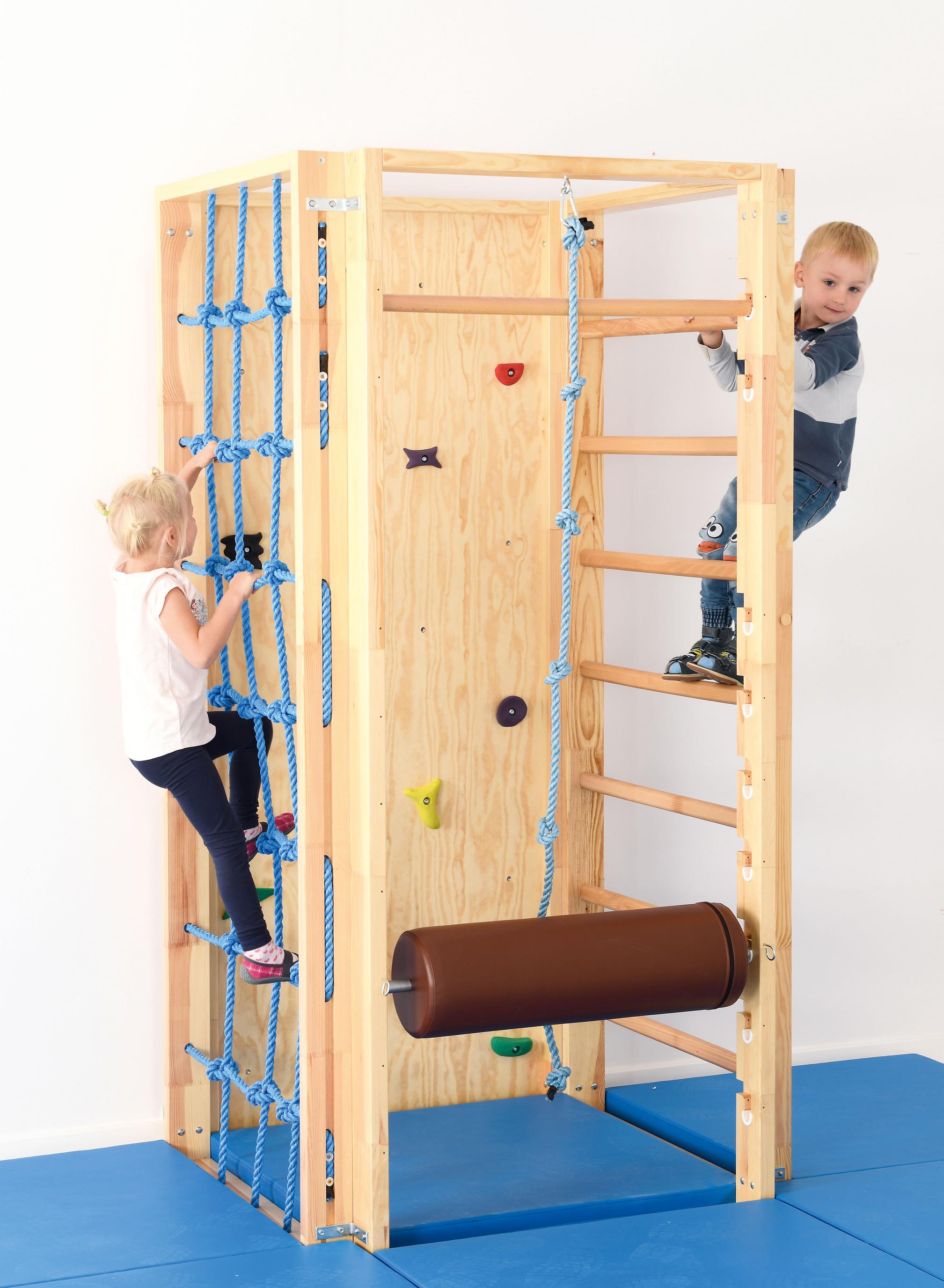 Kinder klettern an einer sicheren Turnhallenkletterwand.