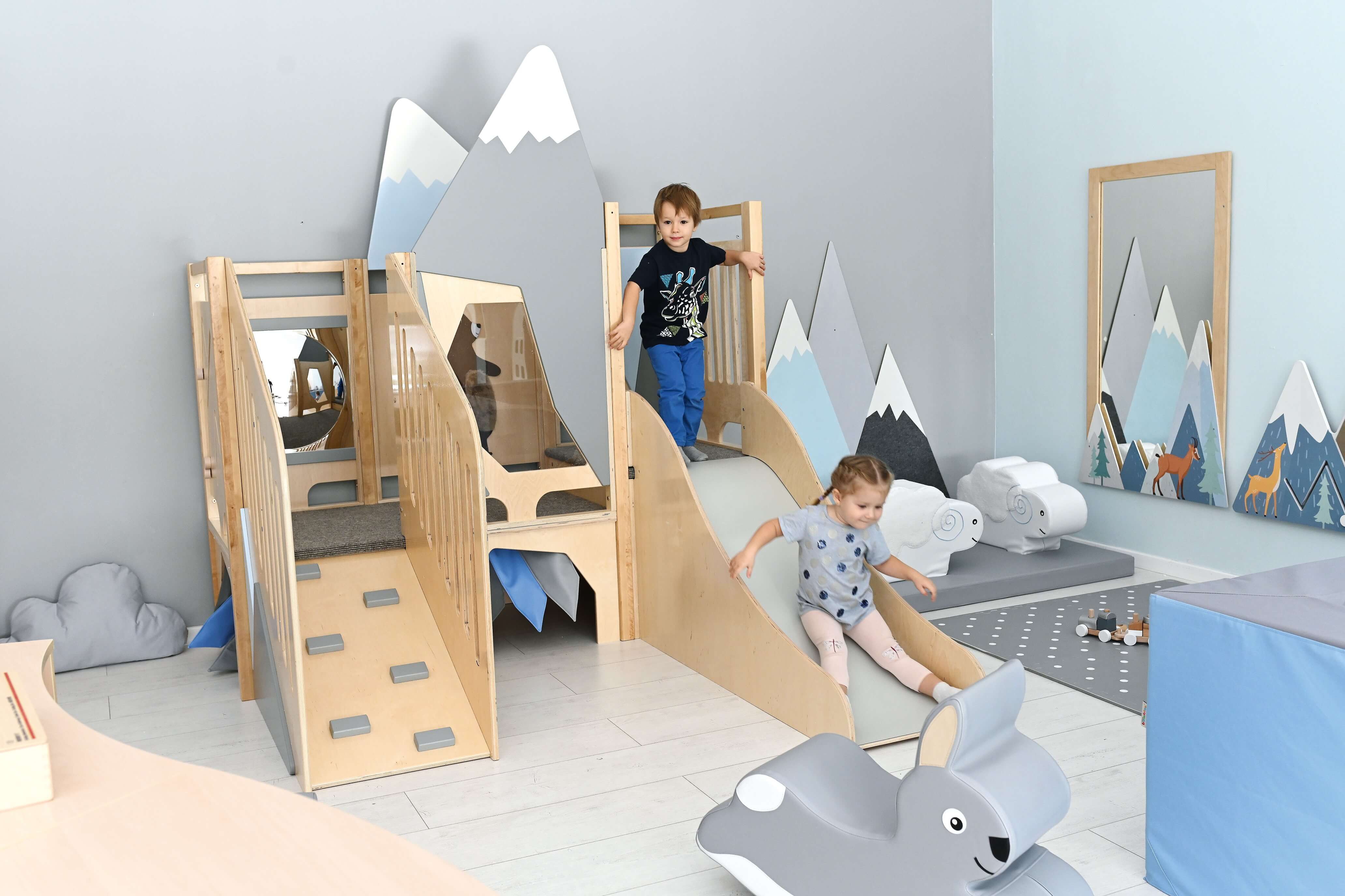 Kindergarten Spielpodest Alpenblick im Gruppenraum Kinder spielen auf Rutsche 2