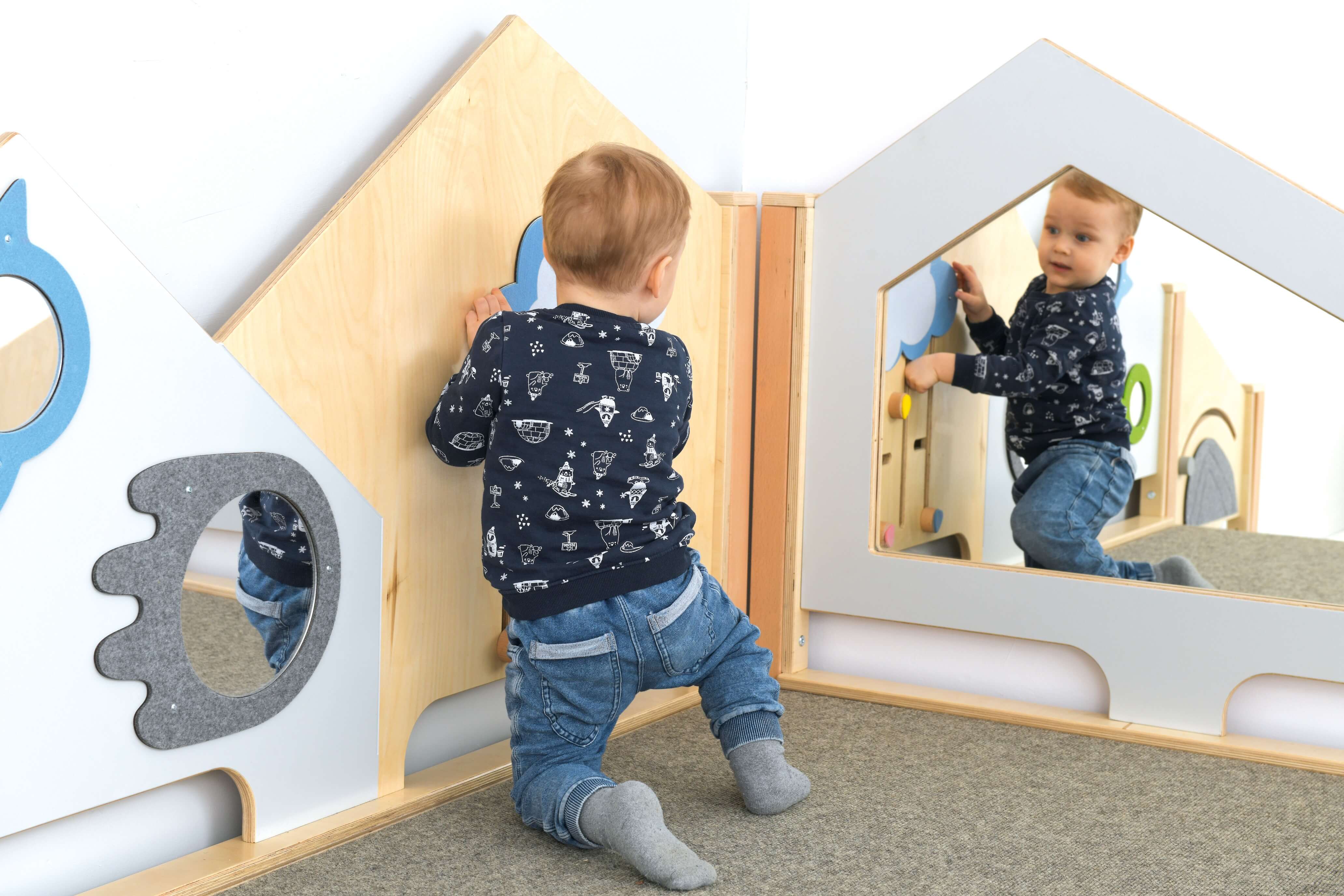 Kindergarten Spielpodest Saphir 2 Krippenkind schaut in den Spiegel 2