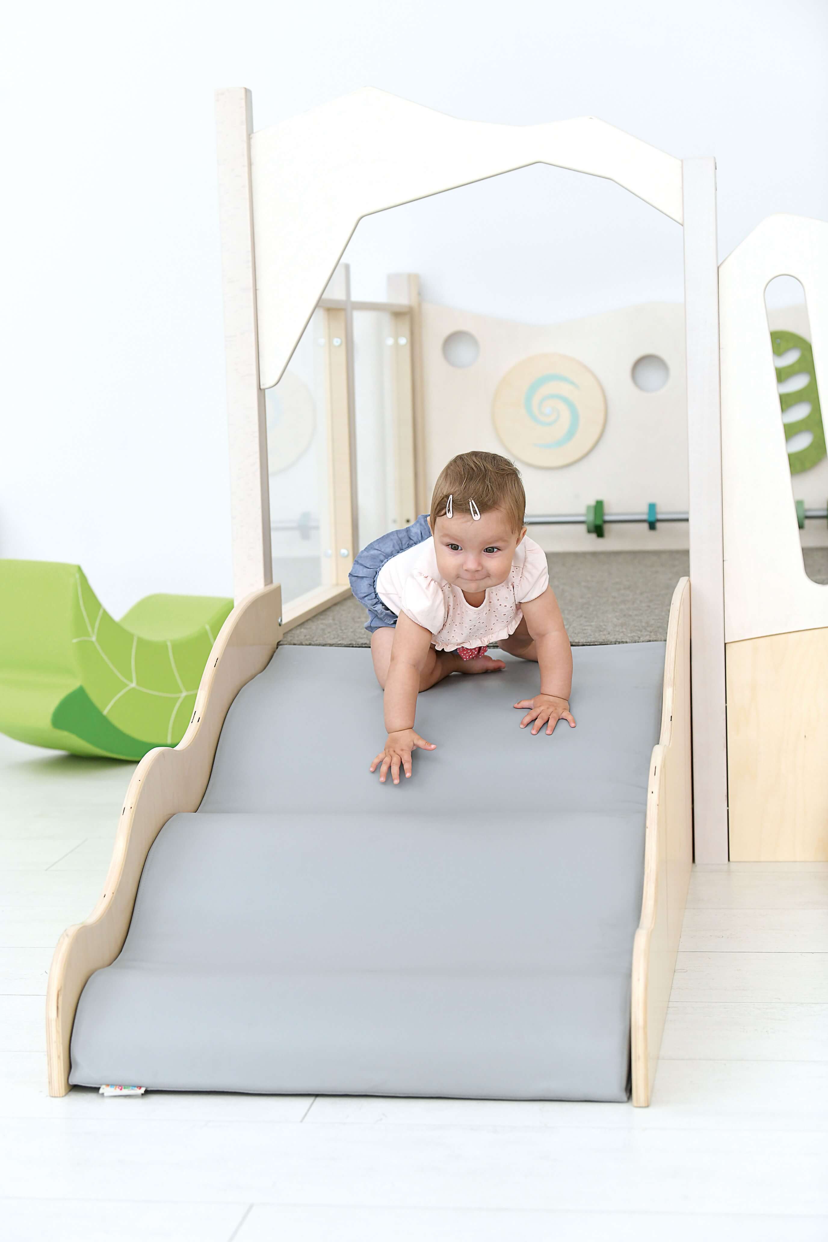 Spielpodest Iris für Kindergarten Detailansicht Rutsche mit Krippenkind