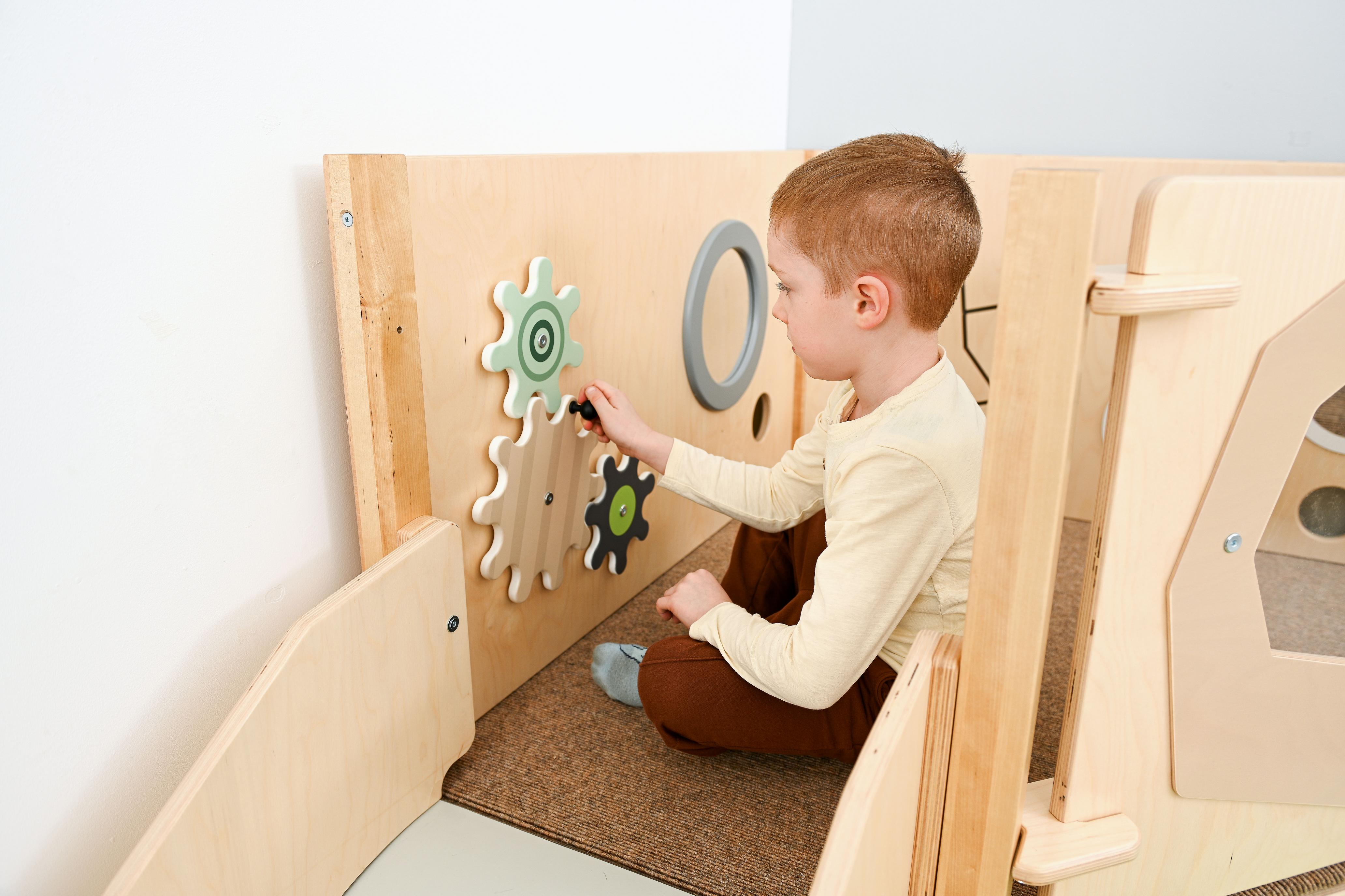 Sensorische Spielecke auf Hochebene mit Zahnradwand.