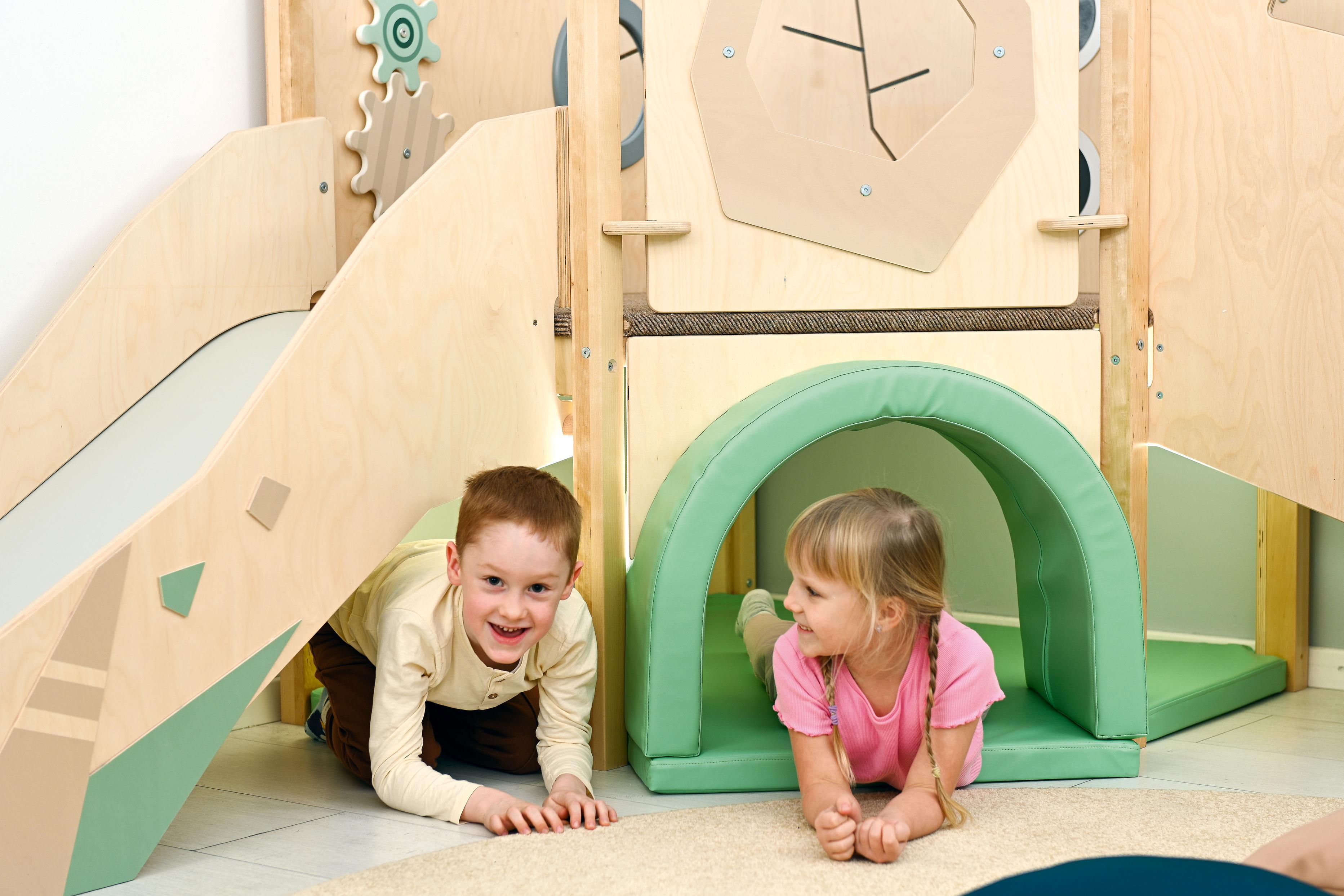 Sensorische Spielecke Hochebene: Kinder spielen im Krabbeltunnel.