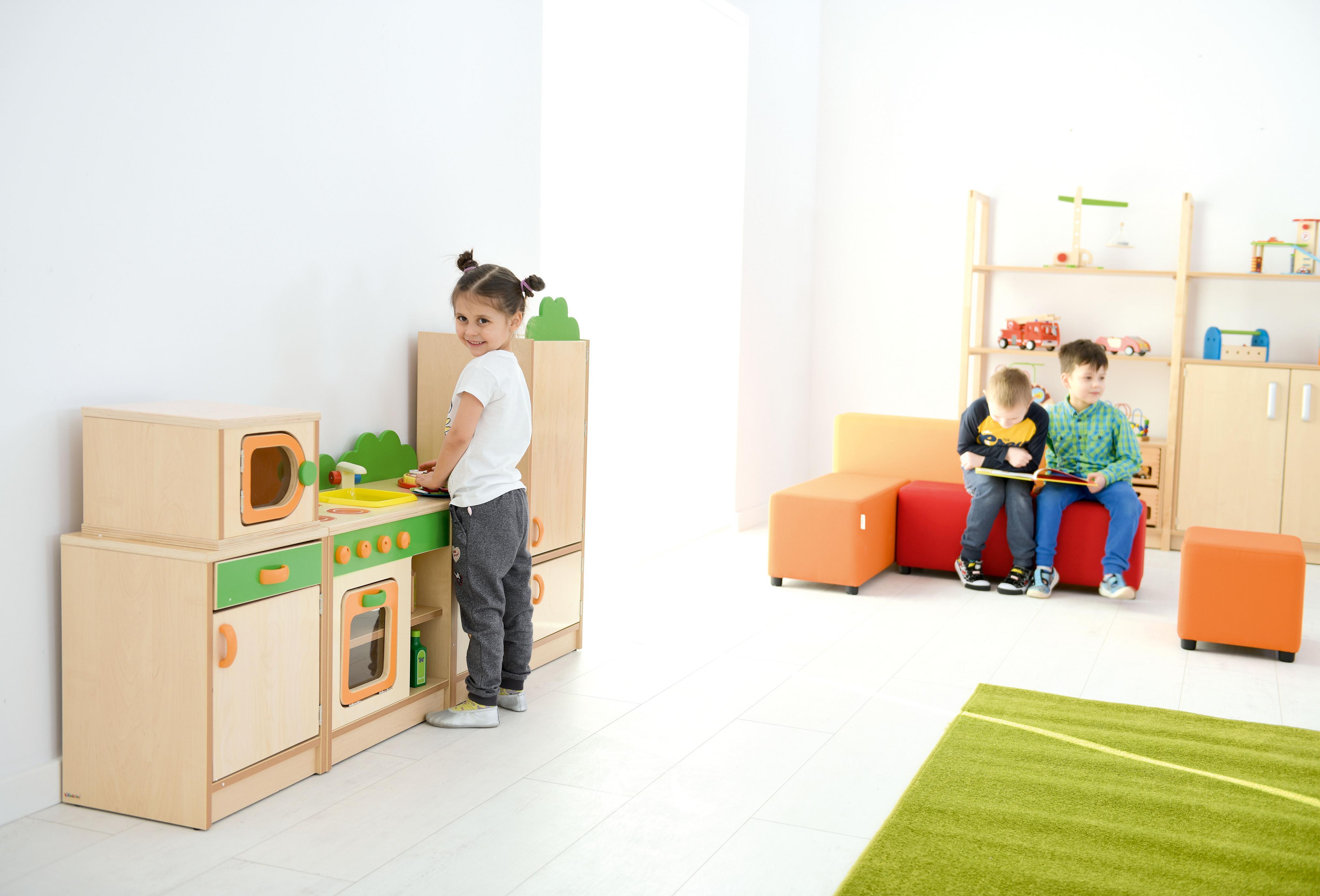 Kind spielt an Spielküche Hannah, Herd mit Spüle im Gruppenraum
